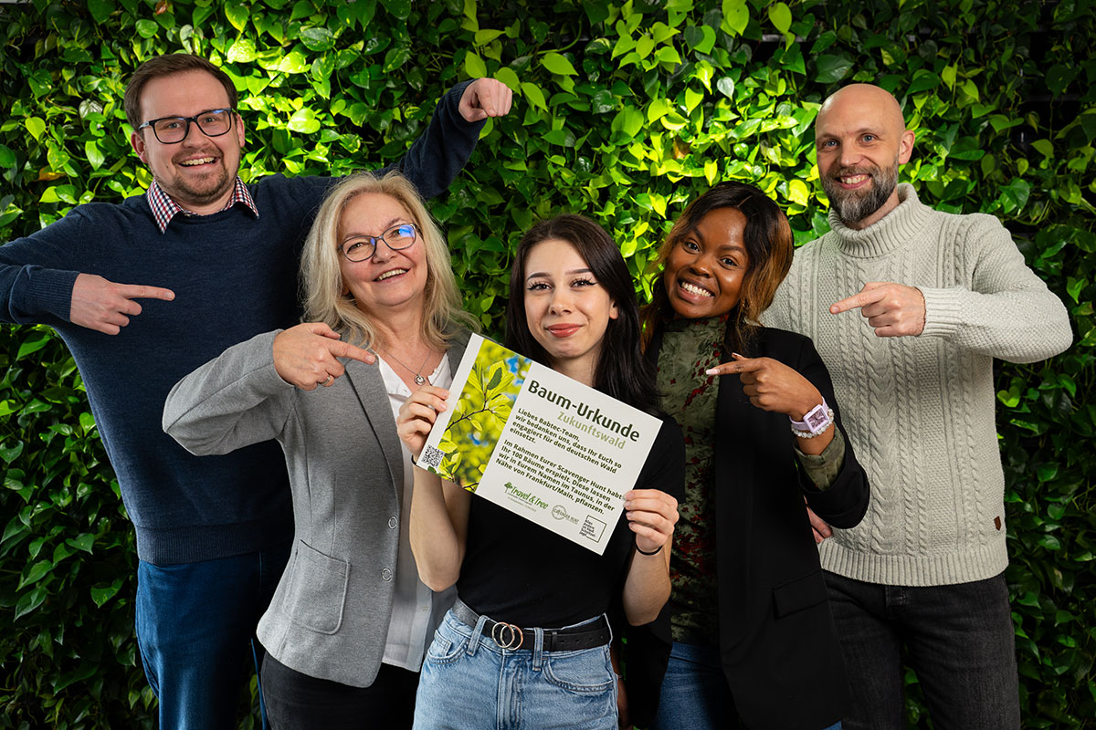 Babtec team members with the "Future Forest Tree Certificate" in front of a leafy green background. 